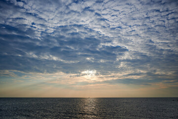 Naklejka na ściany i meble ship for fishing at horizon between clouds, light and sea