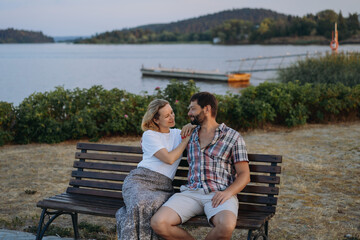 Fototapeta premium happy loving caucasian couple sitting by the lake