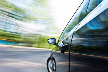 Obraz premium Mirror view of speeding car with blurred road