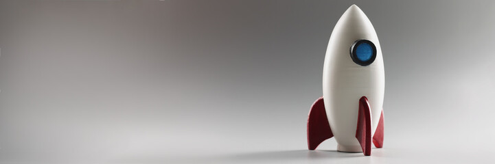 Miniature rocket toy stand on surface, rocketship as symbol for business project and startup