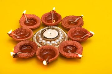 Concept of indian festival diwali. Traditional oil lamps on yellow background.