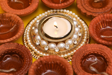Concept of indian festival diwali. Traditional oil lamps on yellow background.