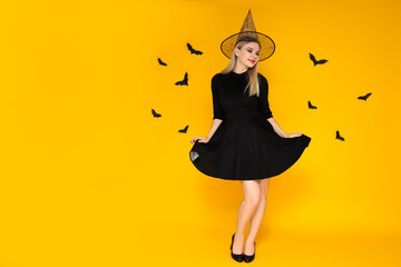 Concept of Halloween, young woman on yellow background