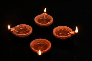 Concept of indian festival diwali. Traditional oil lamps on dark background.