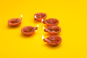 Concept of indian festival diwali. Traditional oil lamps on yellow background.