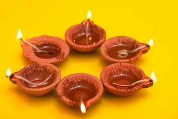 Concept of indian festival diwali. Traditional oil lamps on yellow background.