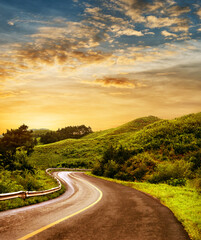Fototapeta premium Curved asphalt road in high mountains at sunrise