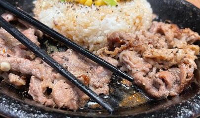 selective focus grilled beef steak with korean sauce bulgogi on top of rice with slice of pepper and sweet corn - korean and japanese food style