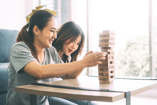 Young Adult Southeast Asian Couple Relax Lifestyle Playing Jenga Board Game At Home