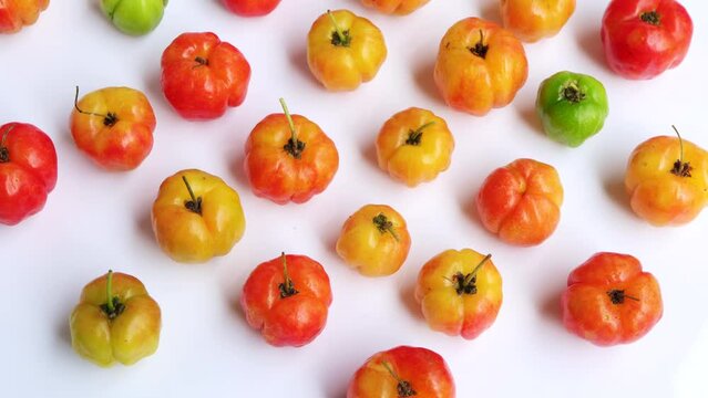 Barbados cherry, Malpighia emarginata, red acerola cherry on white background. Selective focus. Rotating on turn table. 