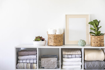 Potted plants in ecology straw baskets on shelf of bed linens cupboard textile arrangement storage