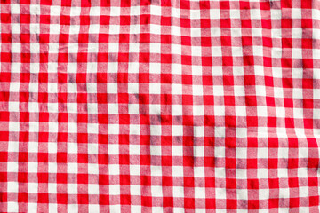 Naklejka premium Red checkered picnic tablecloth as background, top view