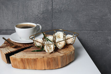 Fototapeta Decorative gold holder with flowers and cup of coffee on white table. Interior design obraz