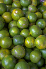 Close up of fresh green orange. Bunch of green lemon at market