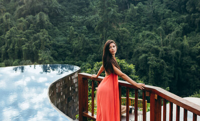 Beautiful young woman standing by swimming pool