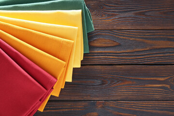 Fototapeta na wymiar Different colorful napkins on wooden table, top view. Space for text