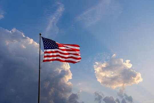 USA Flag flowing in the wind with dramatic sky in the background
