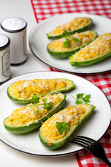 Baked Zucchini boats stuffed with ricotta cheese, tuna fish, egg, bread crumbs and parmesan cheese. Vertical image.