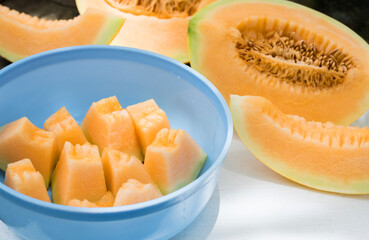slice of melons in bowl, fresh Melon or cantaloupe, Cantaloupe melons on wood background, Favorite fruit in summer