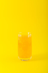 Mango Yuzu Drink with Coconut jelly. Fruit iced lemonade on yellow background. Refreshing tropical cocktail in tall glass. Selective focus, copy space