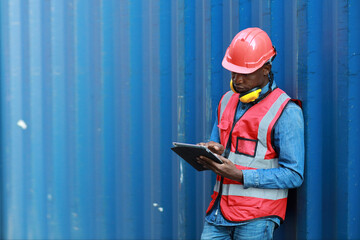 Foreman using tablet and walkie talkie radio control loading containers box. Engineer or worker with safety hat work at container cargo site and checking industrial container cargo freight ship.