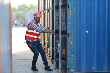 Foreman opens container door to view goods inside and control loading containers box. Engineer or worker with helmet work at container cargo site and checking industrial container cargo freight ship.