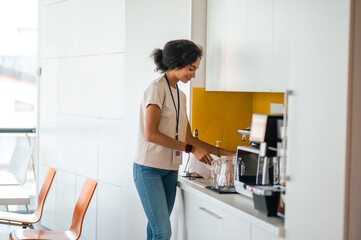 Female office worker in the office swithing on a microwave oven