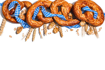 Oktoberfest concept - pretzels with traditional pattern ribbon and ears wheat isolated on white