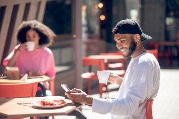 Two young people having coffee at the street cafe