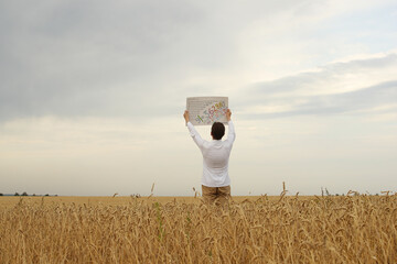 Young man in white shirt with drawing with numbers in hands in the wheat field on a grey sky background. Pavel Kubarkov, i in field. Photo was taken 28 August 2022 year, MSK time in Russia. - 535191508