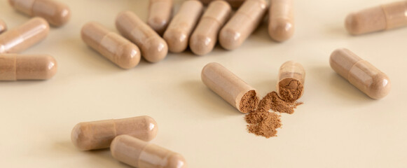 Opened Medical capsules on light beige close up. Taking dietary supplements