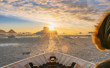 Kreuzfahrtschiff fährt bei einen dramatischer Sonneuntergang / Abendstimmung durch die winterliche Cierva Cove - ein tiefer Meeresarm an der Westseite der Antarktischen Halbinsel, umringt von der Cier - obrazy, fototapety, plakaty