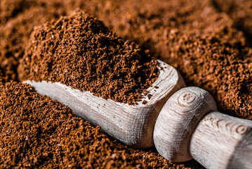 Fresh, ground coffee in wooden scoop.