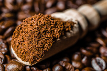 Ground coffee in scoop and coffee beans.