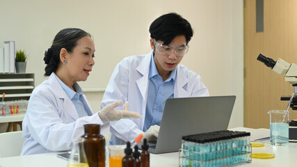 Professional scientists are analyzing test samples, discussing about new test results in science laboratory