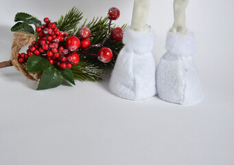 Christmas fir branch and plush boots on a white background. New Year.