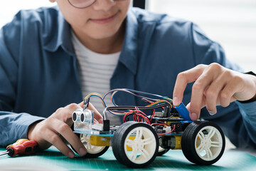 Technology of robotics programing and STEM education concept. Science, Technology, Engineering and Mathematics education. Asian teenager doing robot project in science classroom.