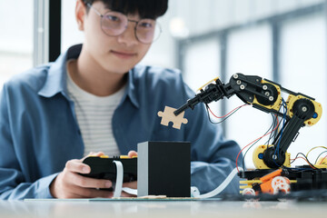 Technology of robotics programing and STEM education concept. Science, Technology, Engineering and Mathematics education. Asian teenager doing robot project in science classroom.