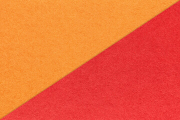 Texture of craft bright orange and red paper background, half two colors, macro. Vintage dense kraft ruby cardboard.