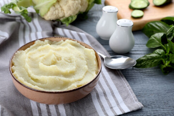 Bowl with tasty puree and ingredients on light blue wooden table