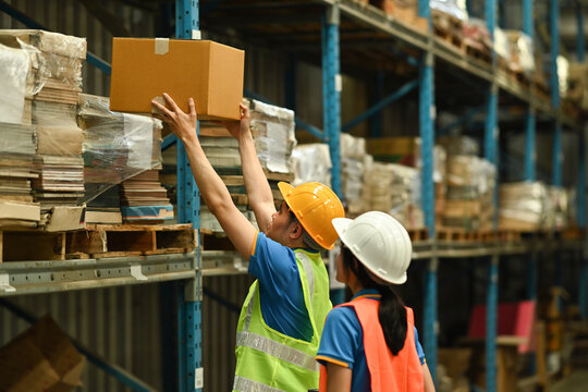 Image of warehouse workers checking inventory and quantity of storage product on shelf full of packed boxes and goods