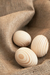 The three wooden egg on the sackcloth as a background