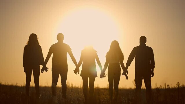 teamwork. team community a holding hands together silhouette at unity sunset. group of people hands. teamwork of workers lifestyle. team in the company running partnership business community hand