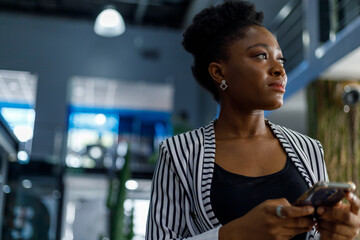 Happy businesswoman using smartphone in office