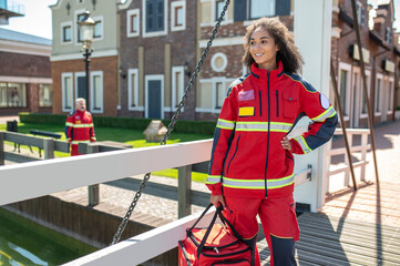 Joyful female paramedic standing on the stree