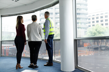 Professional senior engineer builder showing clients around in the new development building