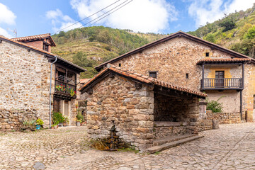 Fototapeta na wymiar Picturesque stone houses with flowers and narrow streets in one of the most beautiful villages in Spain, Bárcena Mayor, Cantabria.