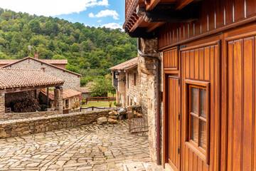 Picturesque stone houses with flowers and narrow streets in one of the most beautiful villages in Spain, Bárcena Mayor, Cantabria.