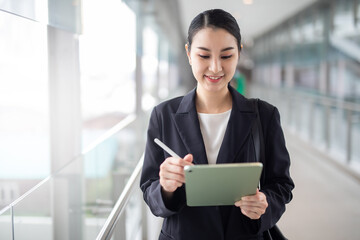 Asian business woman holding a tablet looking smile , smart business concept, smart woman .