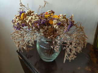 Bouquet of dried flowers in a glass vase on the table